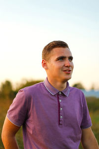 Young man have goals. portrait of smiling young brunette man in purple polo shirt standing outdoor 