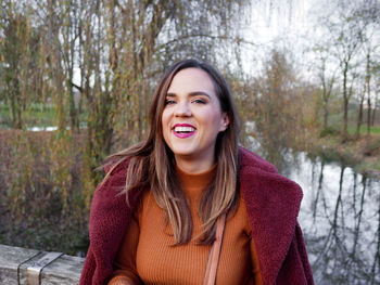 Portrait of happy young woman in winter clothes in park.