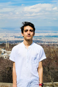 Portrait of young man standing against sky