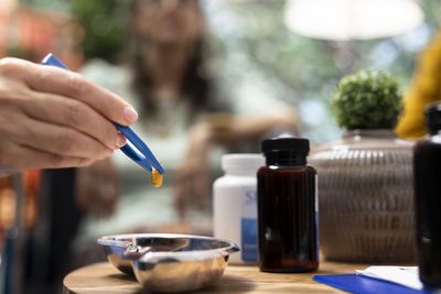 Cropped hand of woman painting on table