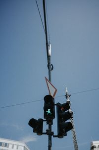 Low angle view of road signal against clear blue sky