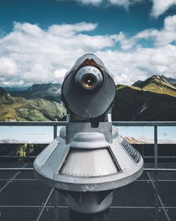 Close-up of coin-operated binoculars against sky