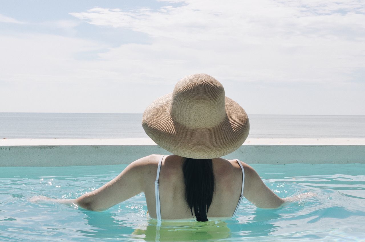 water, sea, sky, leisure activity, real people, horizon over water, one person, nature, lifestyles, beauty in nature, hat, horizon, day, clothing, holiday, trip, vacations, sun hat, women, outdoors, swimming pool, turquoise colored