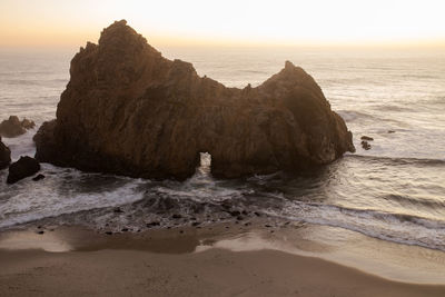 Rock formations in sea against clear sky