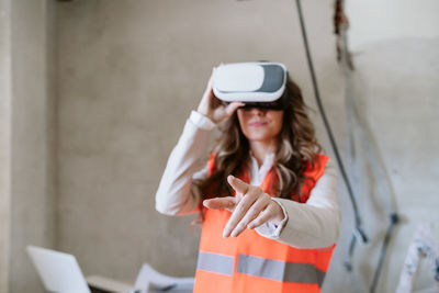 Architect woman in construction site using virtual reality goggles working on vr blueprints