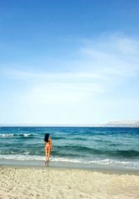 Full length of woman on beach against sky