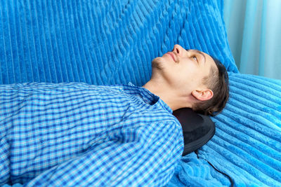 Smiling man lying down on sofa