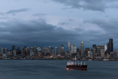 Sea and buildings in city against sky