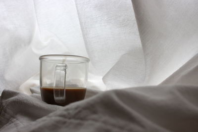 Close-up of drinking glass on bed