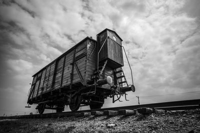 Low angle view of abandoned vehicle on field against sky