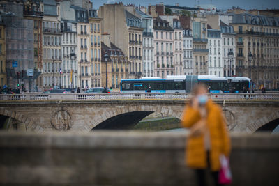 Bridge over street by buildings in city