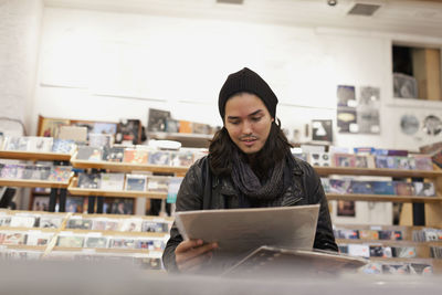 Young man browsing albums in a record store