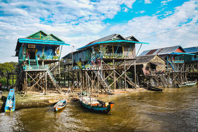 People on house by building against sky