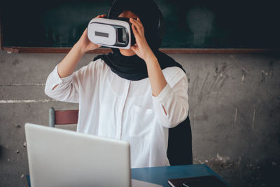 Female teacher using virtual reality simulator in classroom