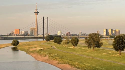 View of bridge over river and buildings against sky