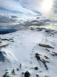 Scenic view of snow covered land against sky