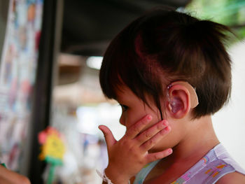 Close-up of cute girl wearing hearing aid