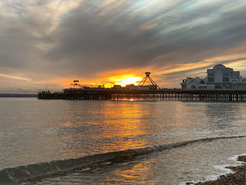 Pier over sea against sky during sunset