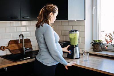 Green smoothies recipes for pregnancy and postpartum, prenatal nutrition. pregnant woman preparing