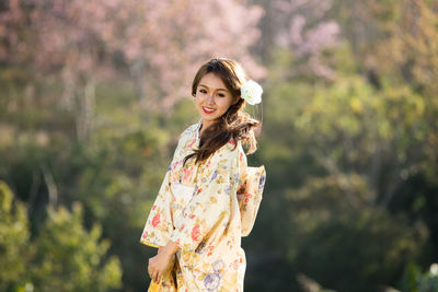 Portrait of smiling young woman standing outdoors