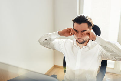 Tired exhausted young man rubbing eyes feeling eyestrain from long computer work. overworked man