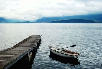 Boat moored in lake against sky