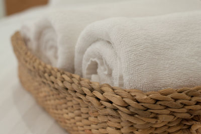 Close-up of towels in wicker basket on bed