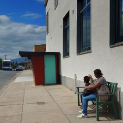 Rear view of couple sitting against sky