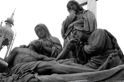 Low angle view of statues against clear sky