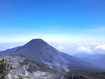 Scenic view of snowcapped mountains against blue sky