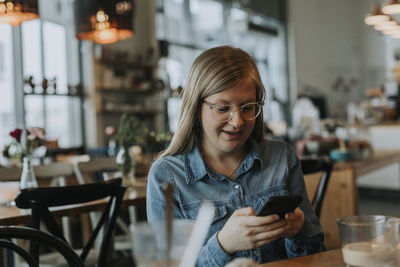 Young man using phone on table