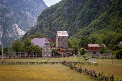 Houses by trees and mountains against sky