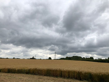 Scenic view of field against cloudy sky