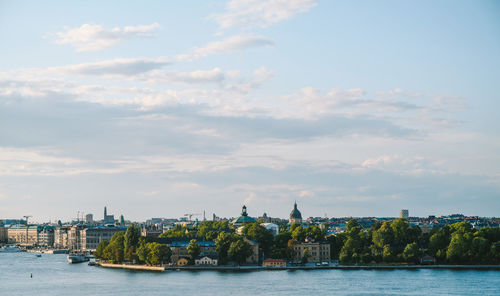 Buildings in city against cloudy sky