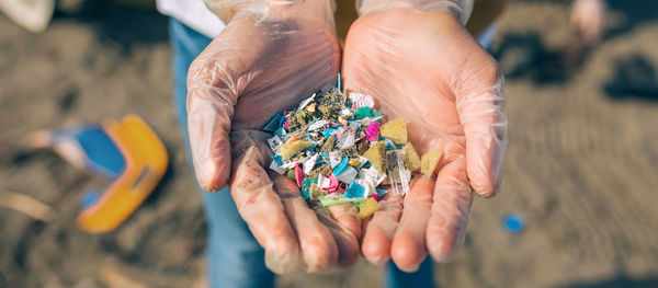 Midsection of woman holding colorful pebbles