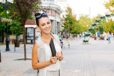 Successful businessman or entrepreneur smiling holding notepad while walking