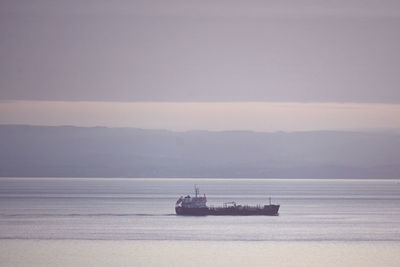 Ship sailing on sea against sky