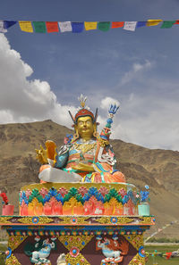 Rear view of woman with arms raised against sky