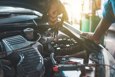 Midsection of mechanic repairing car