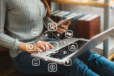 Midsection of woman using digital tablet