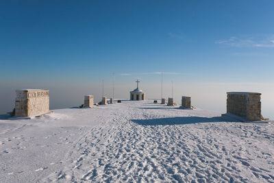 Snow covered land against blue sky