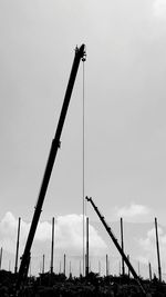 Low angle view of cranes against sky