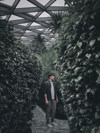 Rear view of man standing against plants