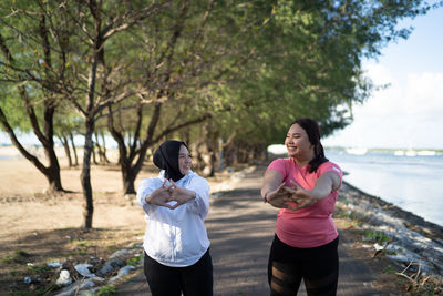 Side view of mother and daughter walking on road