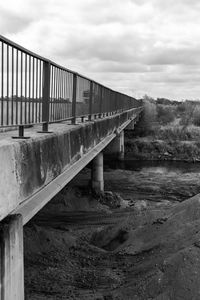 Bridge over empty road against sky