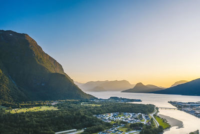 Scenic view of sea and mountains against clear sky