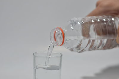 Close-up of hand pouring glass with water