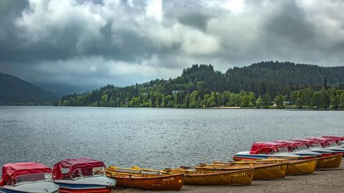 Panoramic view of boats moored in lake against sky