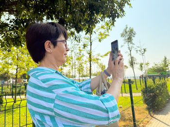 Side view of young woman using mobile phone