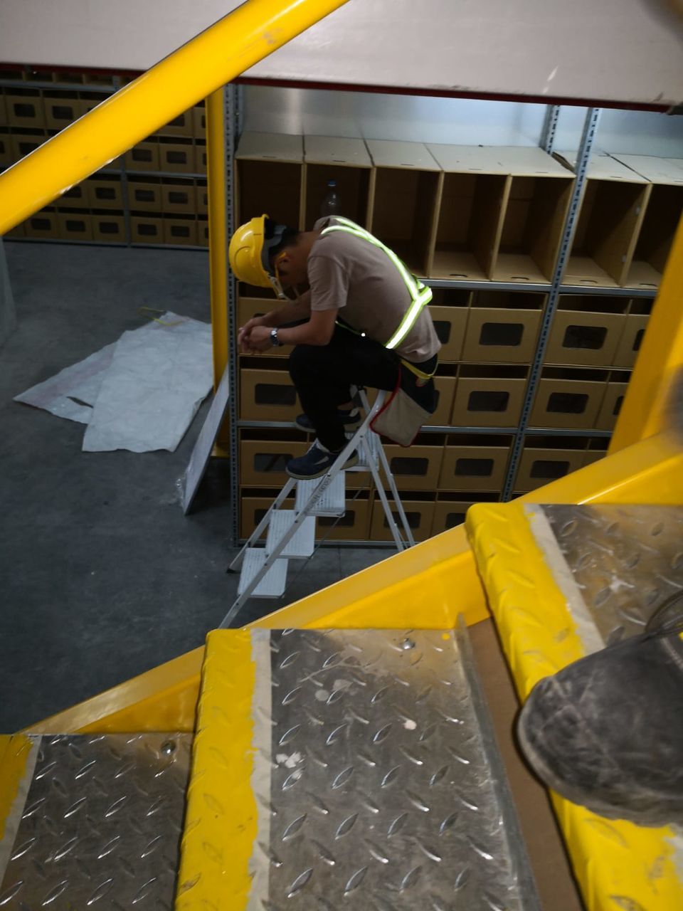 yellow, one person, men, real people, architecture, working, metal, outdoors, staircase, full length, built structure, lifestyles, occupation, railing, day, side view, high angle view, steps and staircases, city